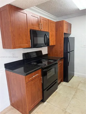 a kitchen with granite countertop a stove and a microwave
