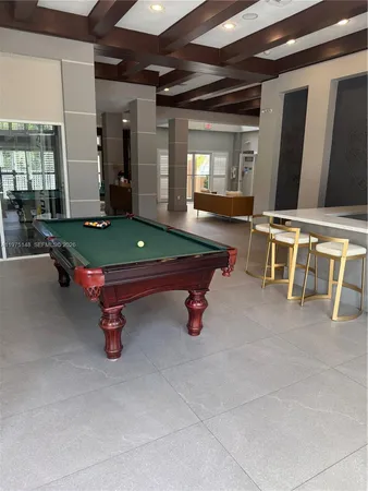 a room with pool table and windows