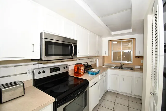 a white stove top oven sitting inside of a kitchen