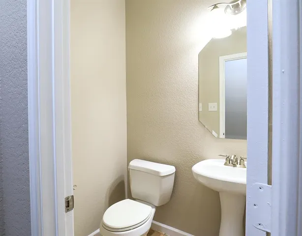 a white toilet sitting next to a bathroom sink