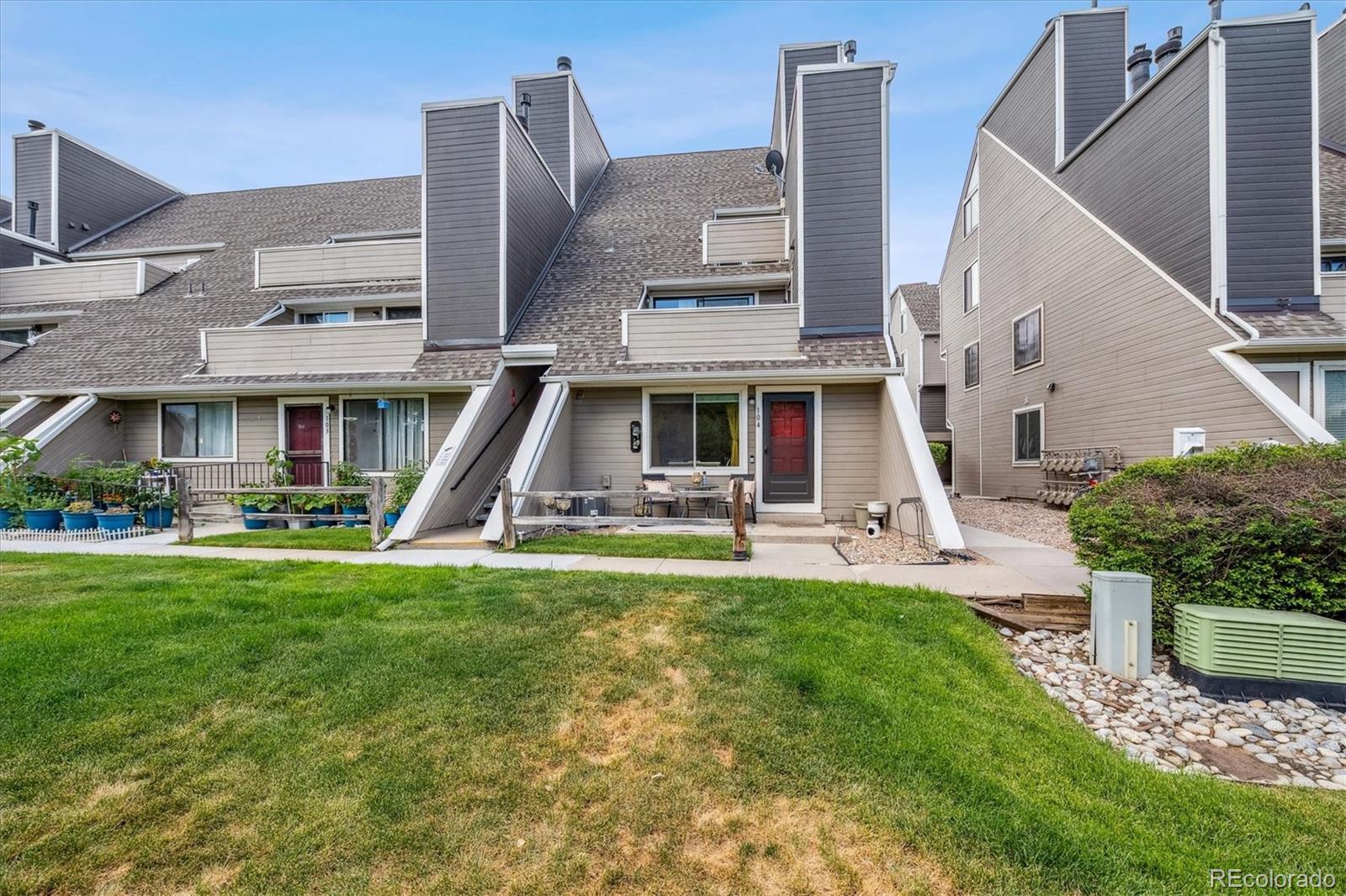 5250 South Huron Way, Unit 7104 Littleton, CO 80120 - Photo 1 of 19 a front view of a house with a yard