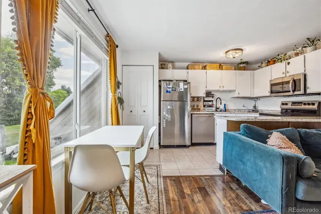 a kitchen with stainless steel appliances granite countertop a refrigerator a stove and a wooden cabinets