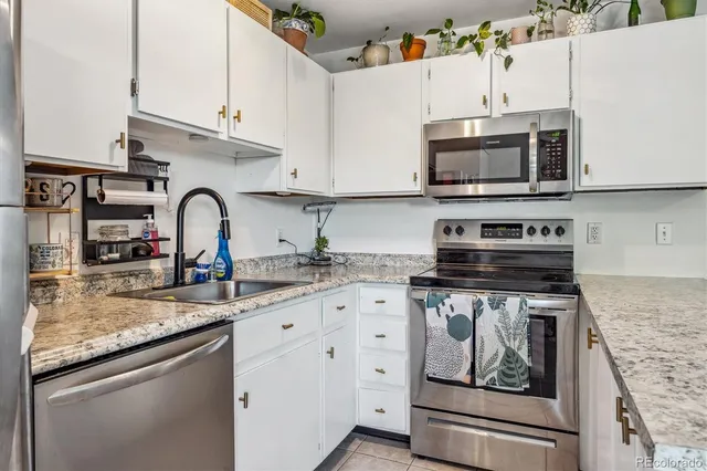 a kitchen with stainless steel appliances granite countertop a stove microwave and sink