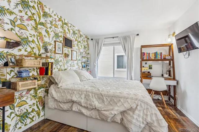 a bed sitting in a bedroom next to a window with a book shelf