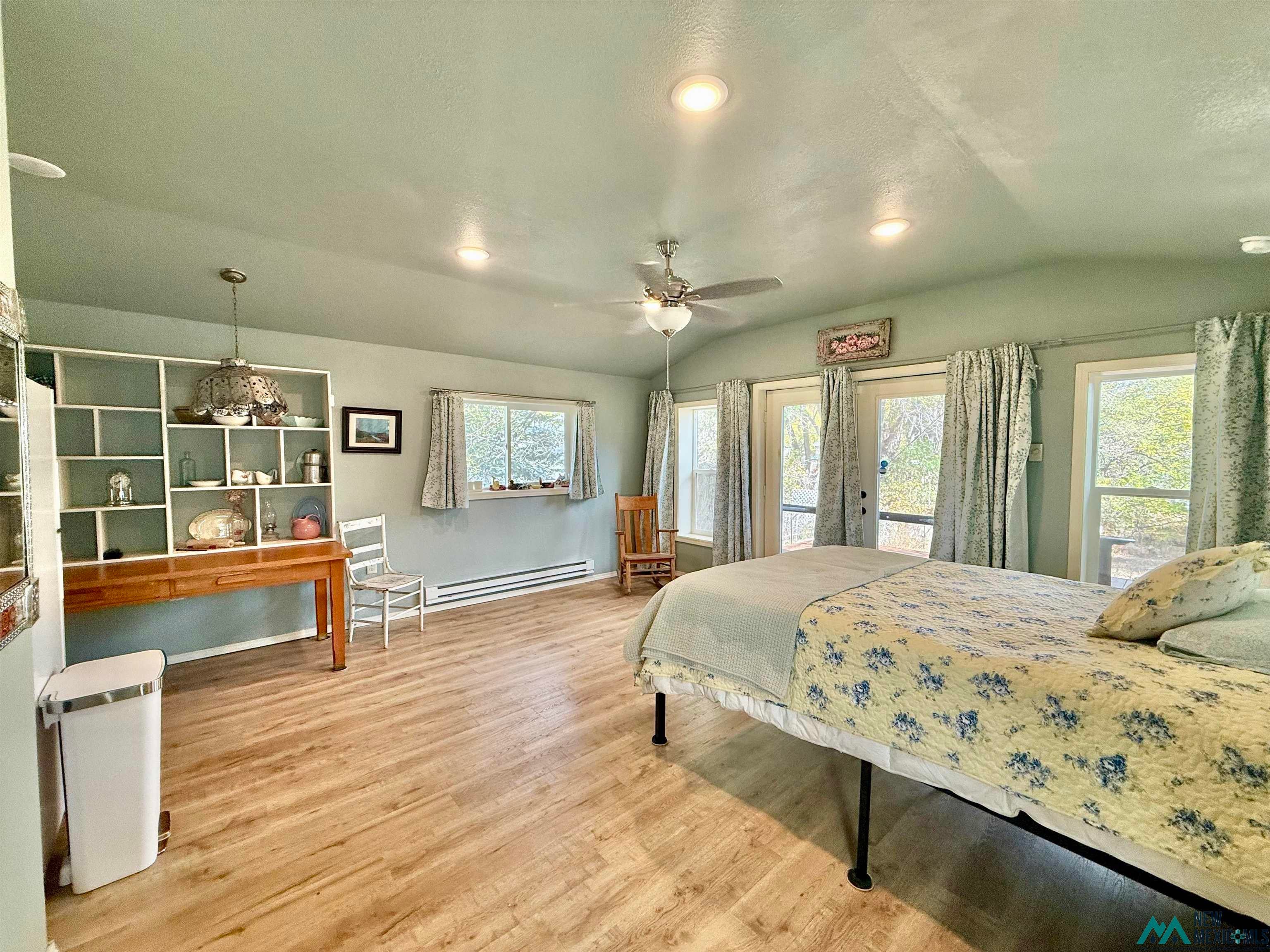 625 South 5th Street Raton, NM 87740 - Photo 27 of 45 Bedroom featuring vaulted ceiling, light wood-type flooring, access to exterior, french doors, and baseboard heating