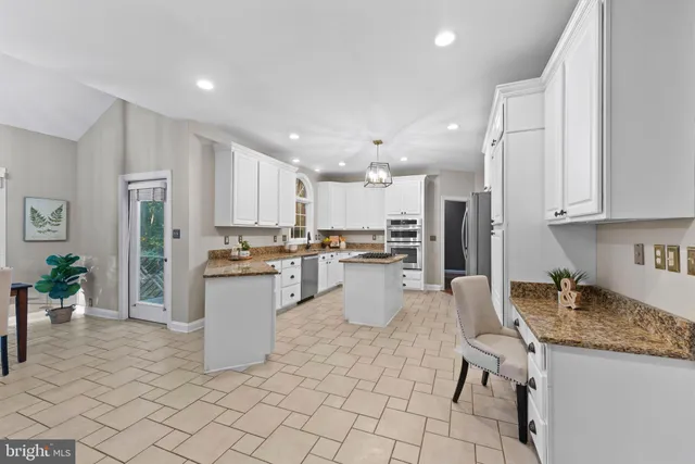 a kitchen with stainless steel appliances granite countertop a sink refrigerator and cabinets