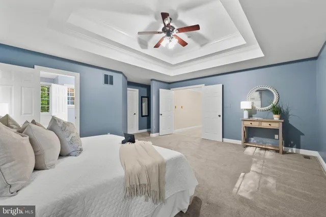 a bedroom with a bed a chandelier furniture and a large window