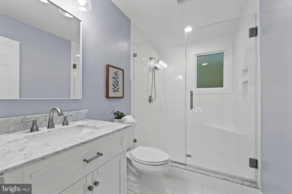 a bathroom with a double vanity sink toilet mirror and shower