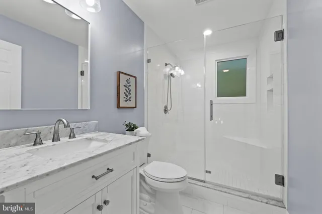 a bathroom with a double vanity sink toilet mirror and shower