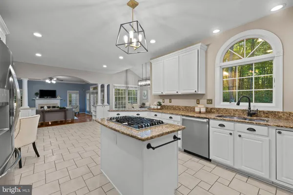 a kitchen with granite countertop stainless steel appliances a stove refrigerator and cabinets