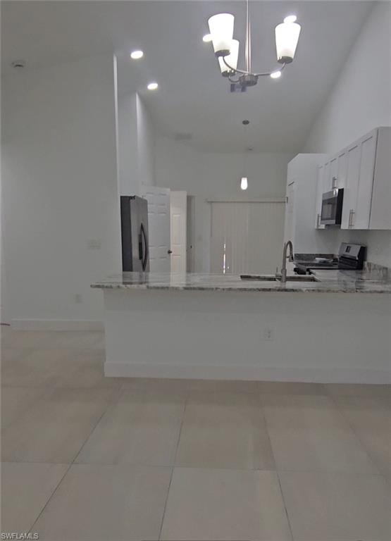 4518 26th Street Southwest Lehigh Acres, FL 33973 - Photo 2 of 15 a kitchen with kitchen island granite countertop a sink cabinets and stainless steel appliances