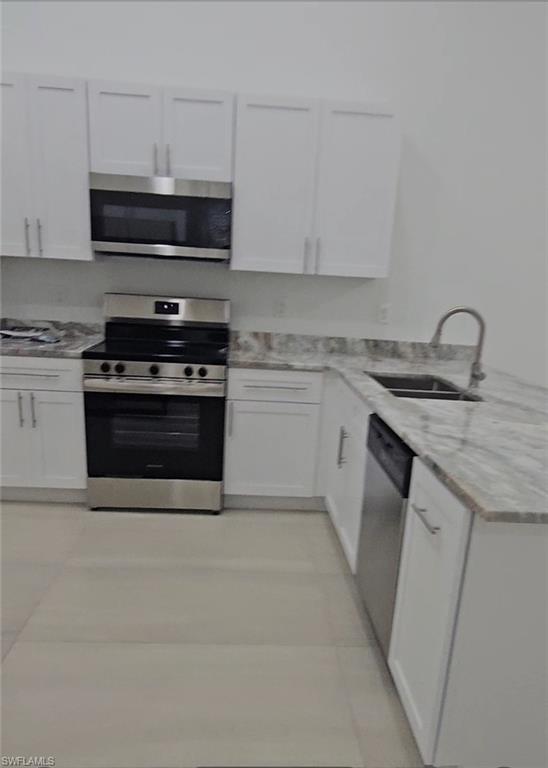 4518 26th Street Southwest Lehigh Acres, FL 33973 - Photo 4 of 15 a kitchen with stainless steel appliances granite countertop a sink and a stove