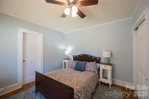 a bedroom with bed window and mirror