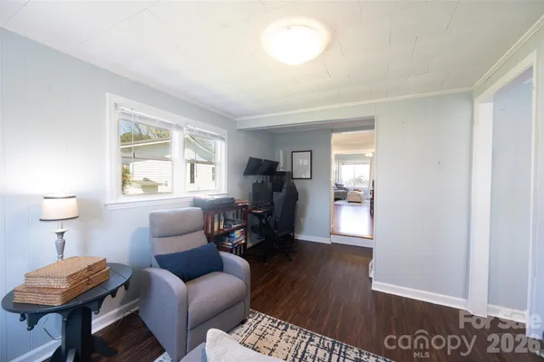 a living room with furniture a flat screen tv and a window