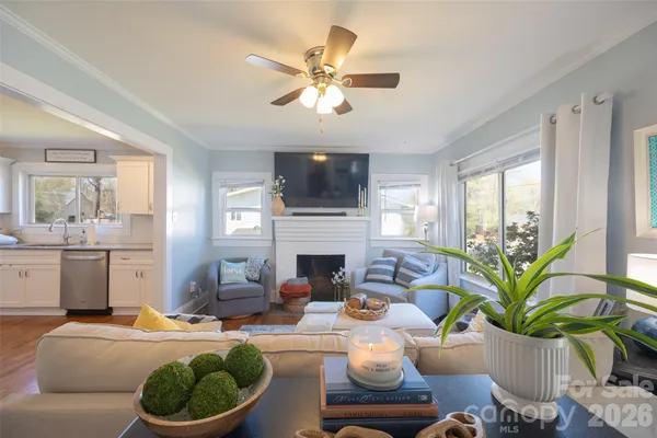 a living room with furniture fireplace and a large window