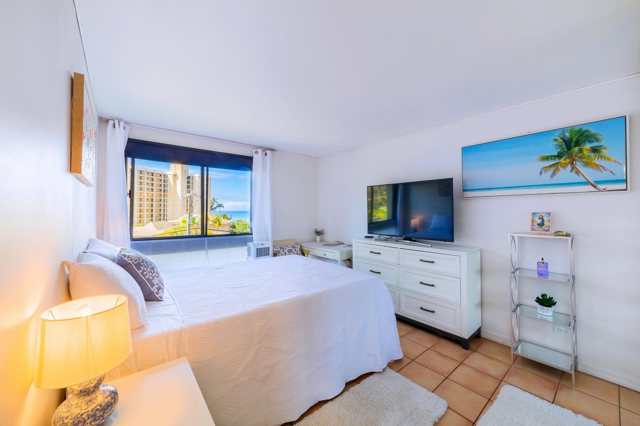 4310 Lower Honoapiilani Road, Unit 302 Lahaina, HI 96761 - Photo 22 of 50 a bedroom with a bed and wooden floor