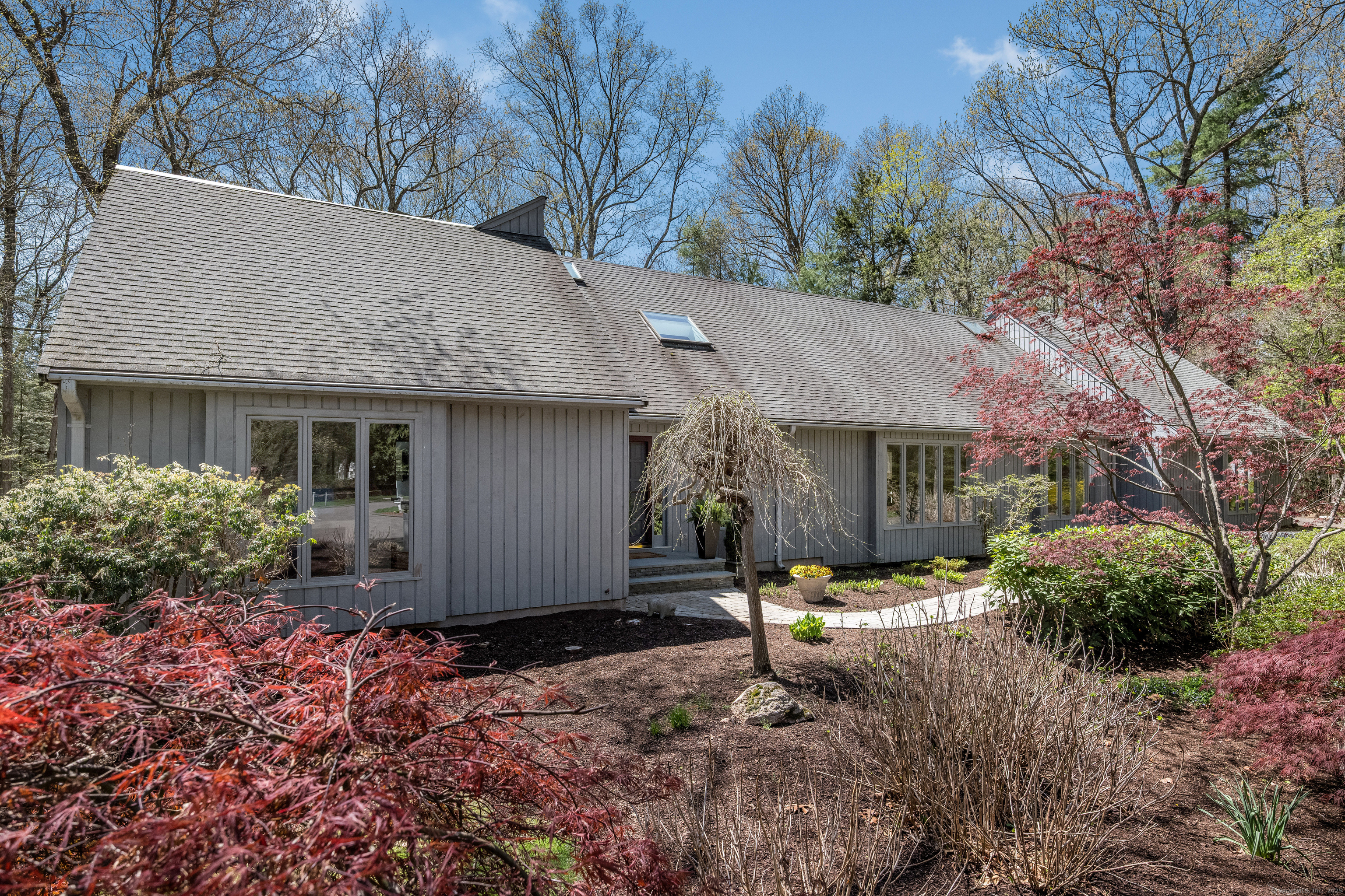 a front view of house with yard and trees around