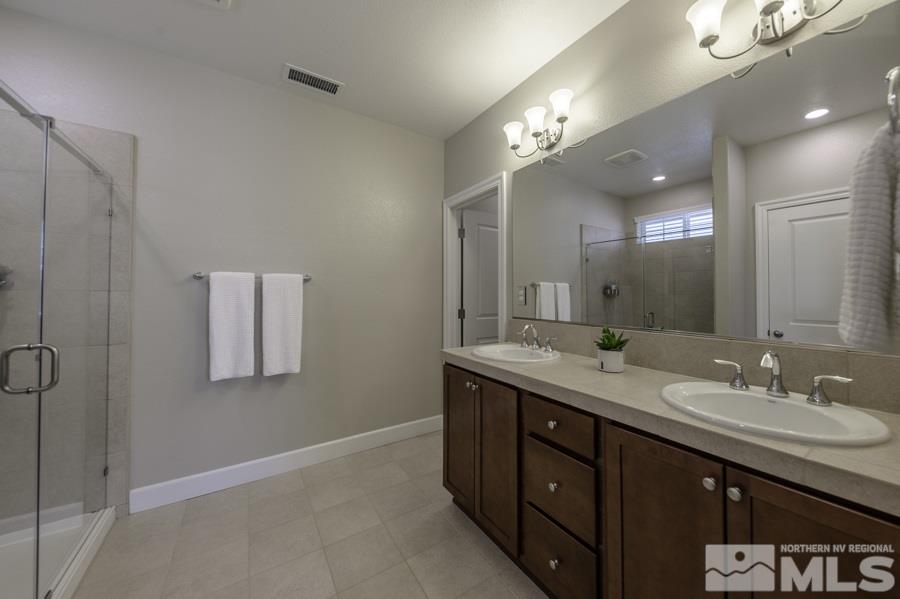 2029 Wind Ranch Road, Unit A Reno, NV 89521 - Photo 15 of 26 a spacious bathroom with a granite countertop sink a mirror and a shower