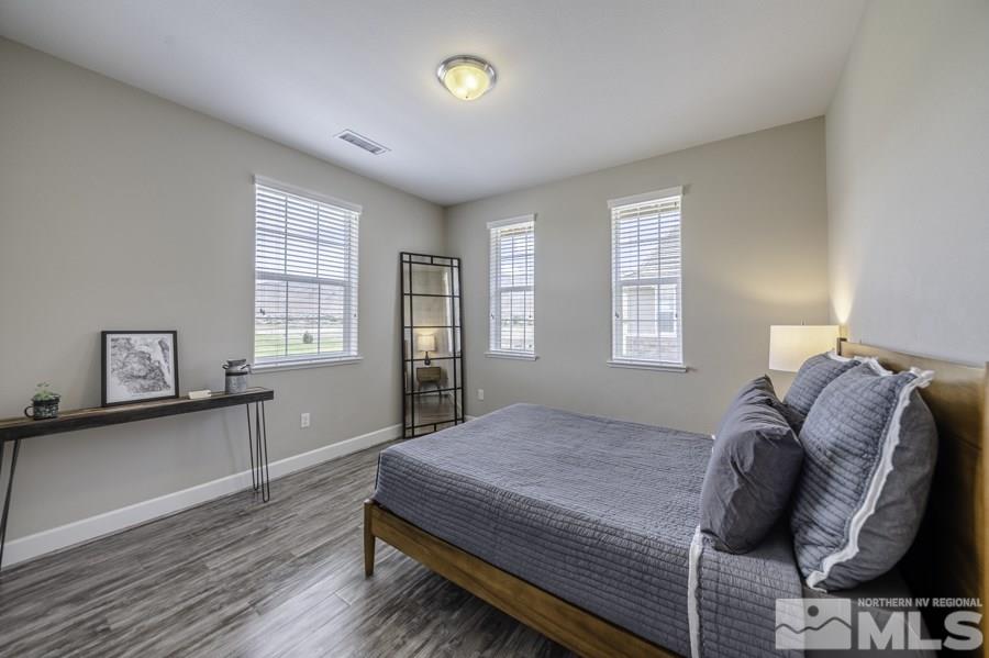 2029 Wind Ranch Road, Unit A Reno, NV 89521 - Photo 18 of 26 a bed sitting in a bedroom next to a window and dresser