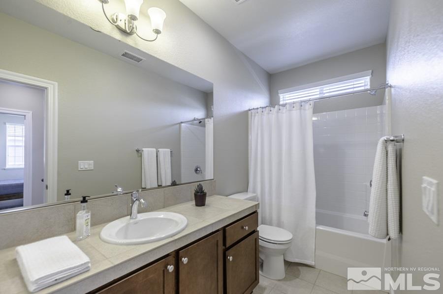 2029 Wind Ranch Road, Unit A Reno, NV 89521 - Photo 19 of 26 a bathroom with a double vanity sink toilet mirror and shower