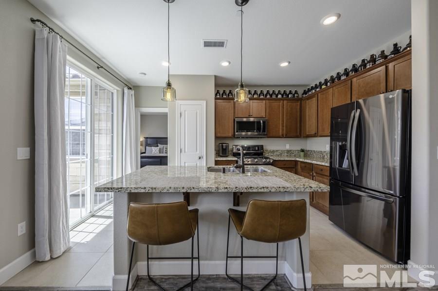 2029 Wind Ranch Road, Unit A Reno, NV 89521 - Photo 5 of 26 a kitchen with granite countertop a counter space cabinets stainless steel appliances and a window
