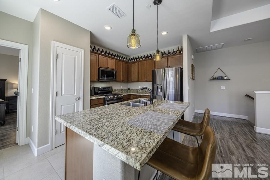 2029 Wind Ranch Road, Unit A Reno, NV 89521 - Photo 6 of 26 a large kitchen with stainless steel appliances granite countertop a sink a stove and a refrigerator