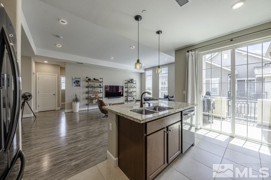 2029 Wind Ranch Road, Unit A Reno, NV 89521 - Photo 8 of 26 a kitchen with stainless steel appliances granite countertop a stove and a large window