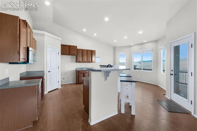 a kitchen with stainless steel appliances granite countertop a sink a stove and a refrigerator