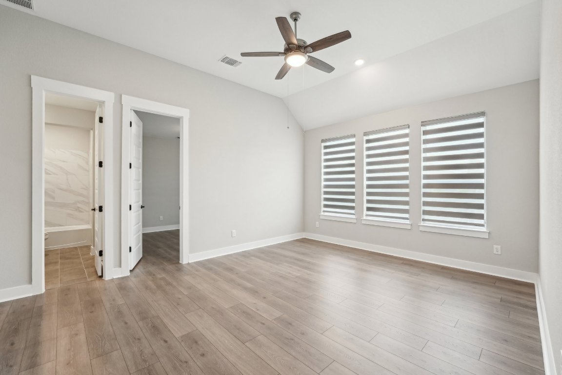 4216 Caroline Mae Cove Pflugerville, TX 78660 - Photo 14 of 32 wooden floor in an empty room with a window