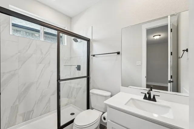 a bathroom with a sink a toilet and shower