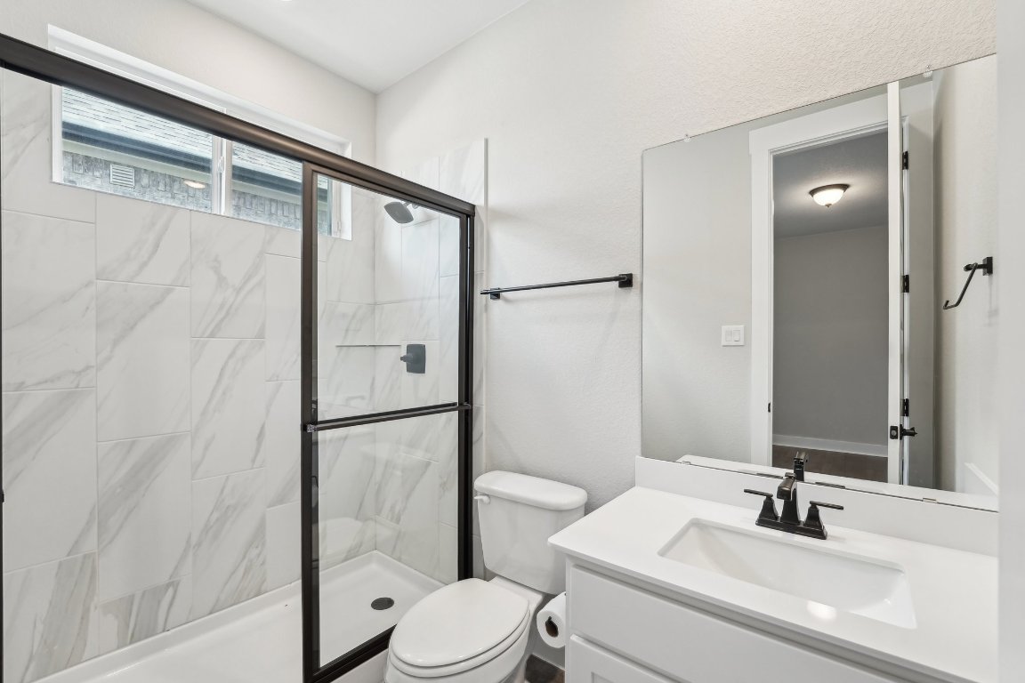 4216 Caroline Mae Cove Pflugerville, TX 78660 - Photo 18 of 32 a bathroom with a sink a toilet and shower