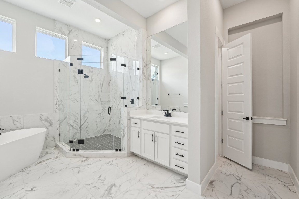 4216 Caroline Mae Cove Pflugerville, TX 78660 - Photo 21 of 32 a bathroom with a double vanity sink toilet and shower