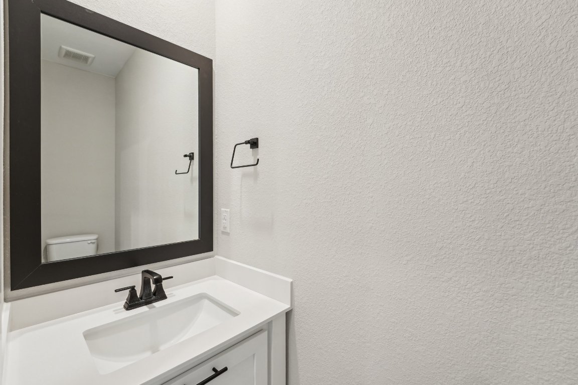 4216 Caroline Mae Cove Pflugerville, TX 78660 - Photo 29 of 32 a bathroom with a sink and a mirror