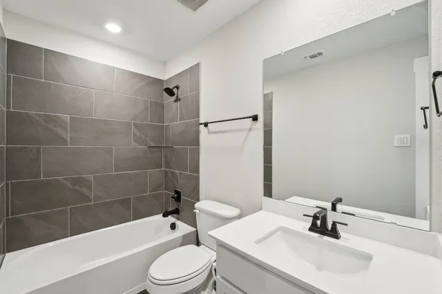 a bathroom with a sink a toilet and bathtub