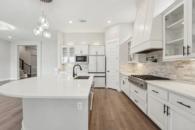 a large kitchen with kitchen island a sink stainless steel appliances and cabinets