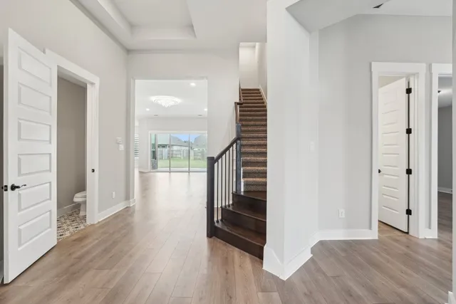 a view of a hallway with wooden floor and staircase