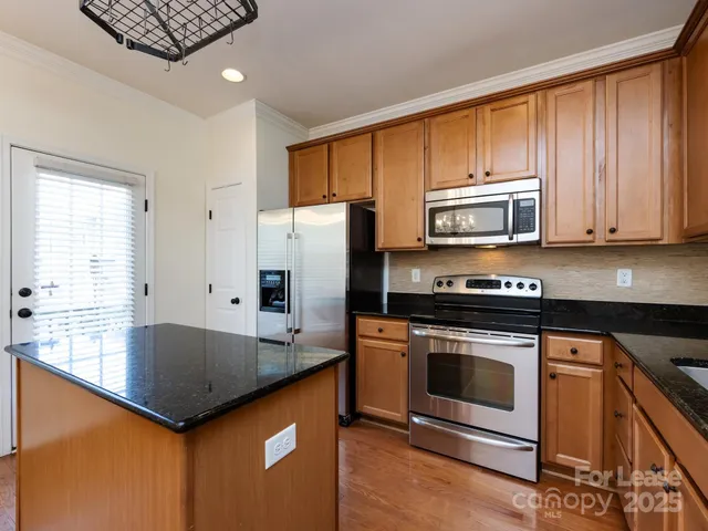 a kitchen with granite countertop a stove and a microwave