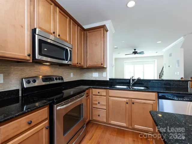 a kitchen with granite countertop cabinets stainless steel appliances and a sink