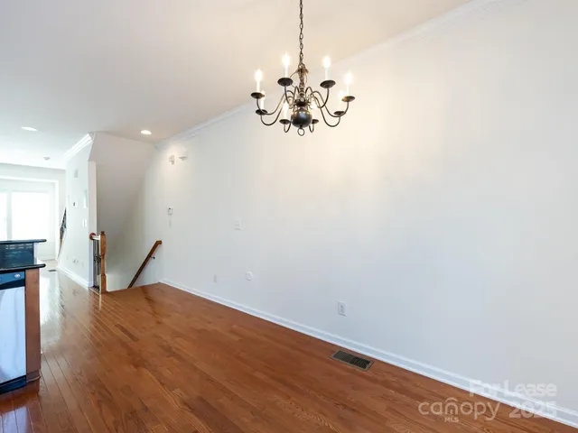 a view of a room with wooden floor and chandelier
