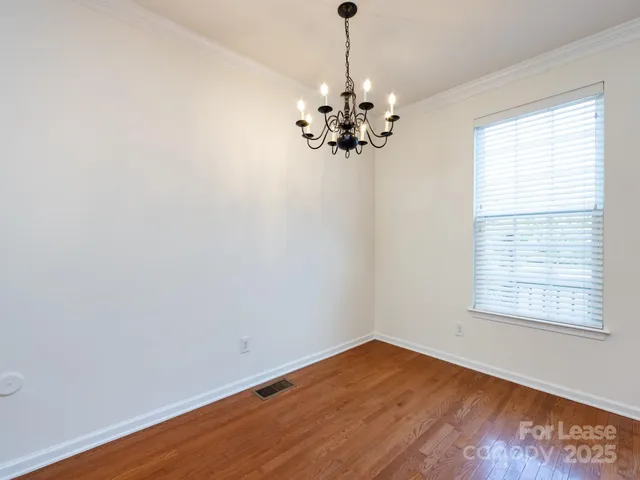 a view of a room with wooden floor chandelier and window