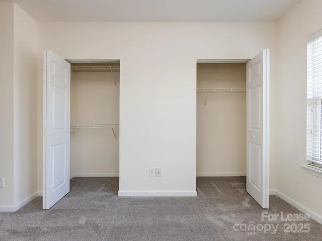 a view of an empty room with windows and bathroom