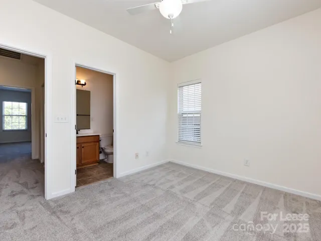 an empty room with a mirror and a fan