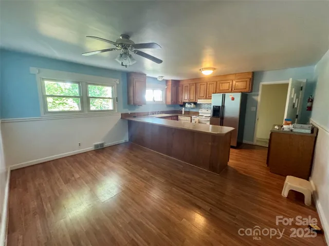 a kitchen with granite countertop a stove a sink and a refrigerator