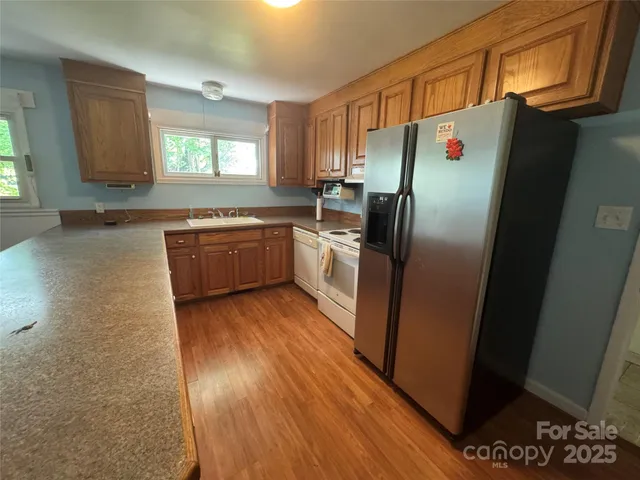 a kitchen with granite countertop a refrigerator stove and sink
