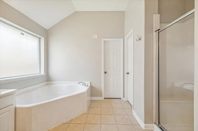 a spacious bathroom with a bathtub and shower