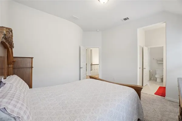 a bedroom with a bed and a large mirror