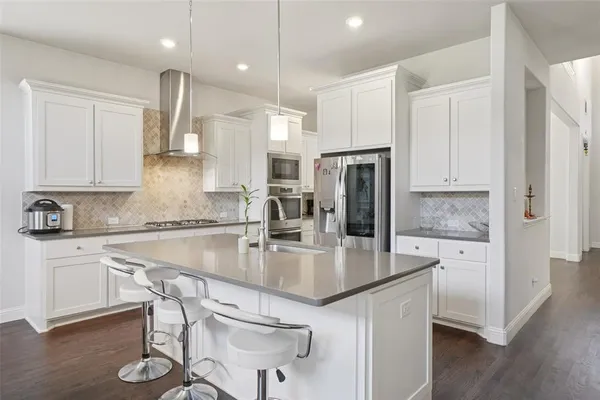 a kitchen with kitchen island granite countertop a sink a center island and stainless steel appliances