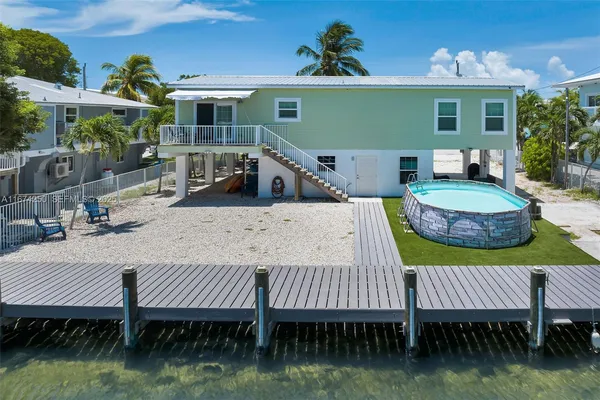 an aerial view of a house with swimming pool and lake view