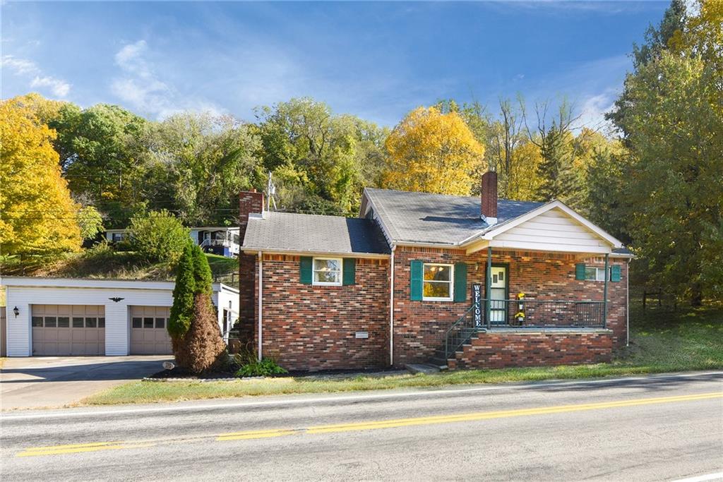 a view of a house with a yard and large tree