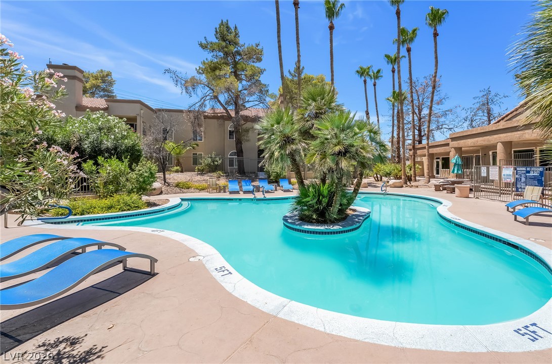 3145 East Flamingo Road, Unit 1092 Las Vegas, NV 89121 - Photo 26 of 33 An inviting community pool with lush landscaping and vibrant blue water awaits.
